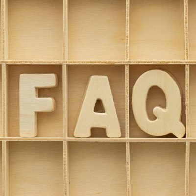 编辑在夜间整理读者反馈邮件与常见问题清单，桌面散落打印稿与荧光笔，屏幕亮光映在眼镜片上